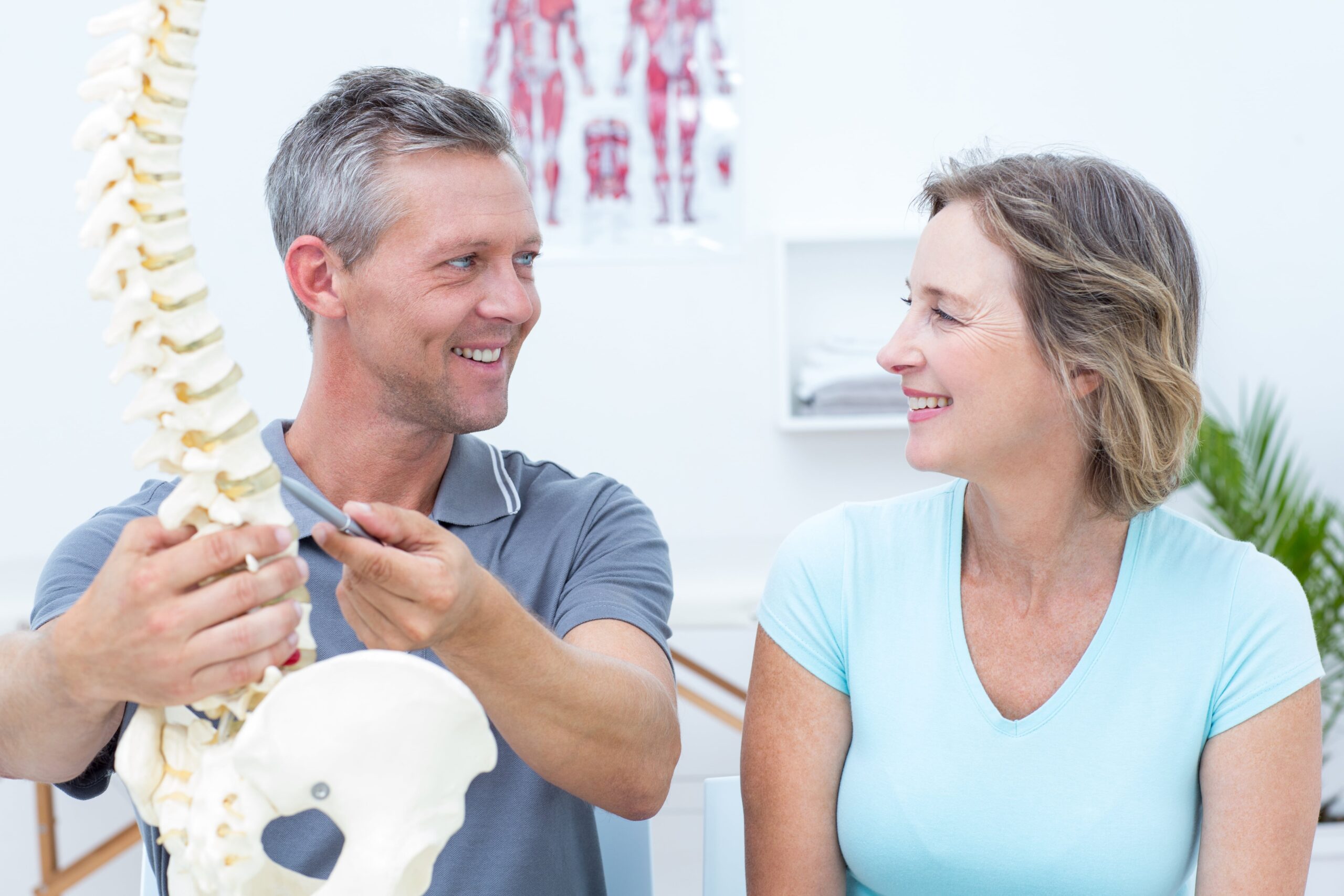 Chiropractor showing spine model to patient.