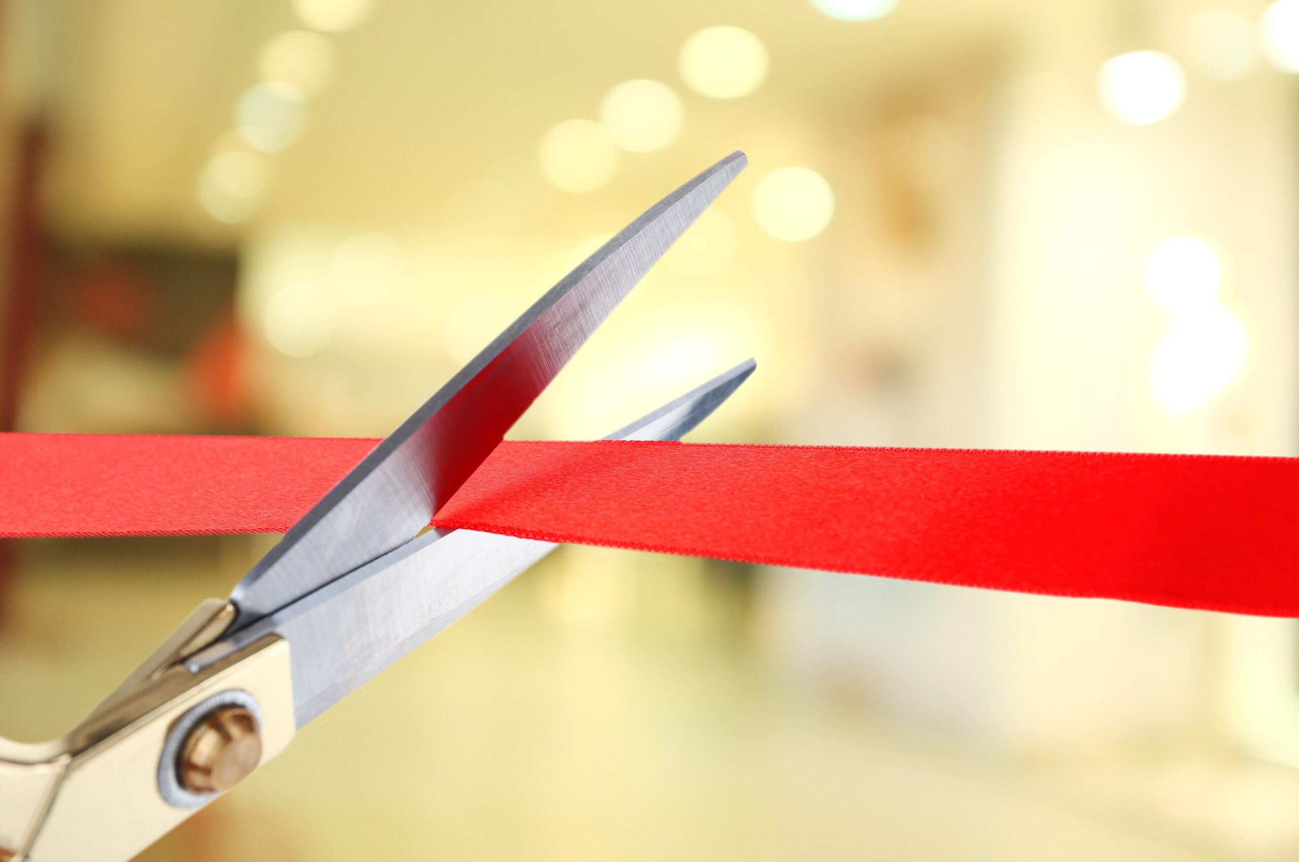 Scissors cutting the red ribbon.