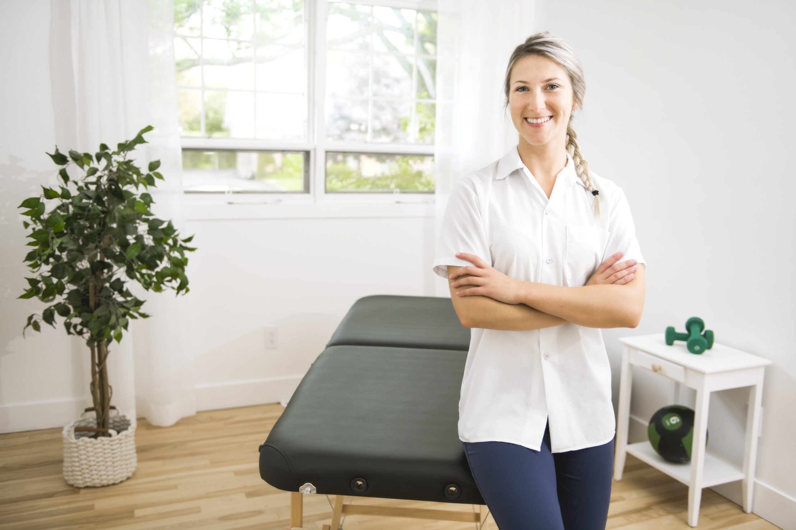 Portrait of chiropractor standing next to exam table.